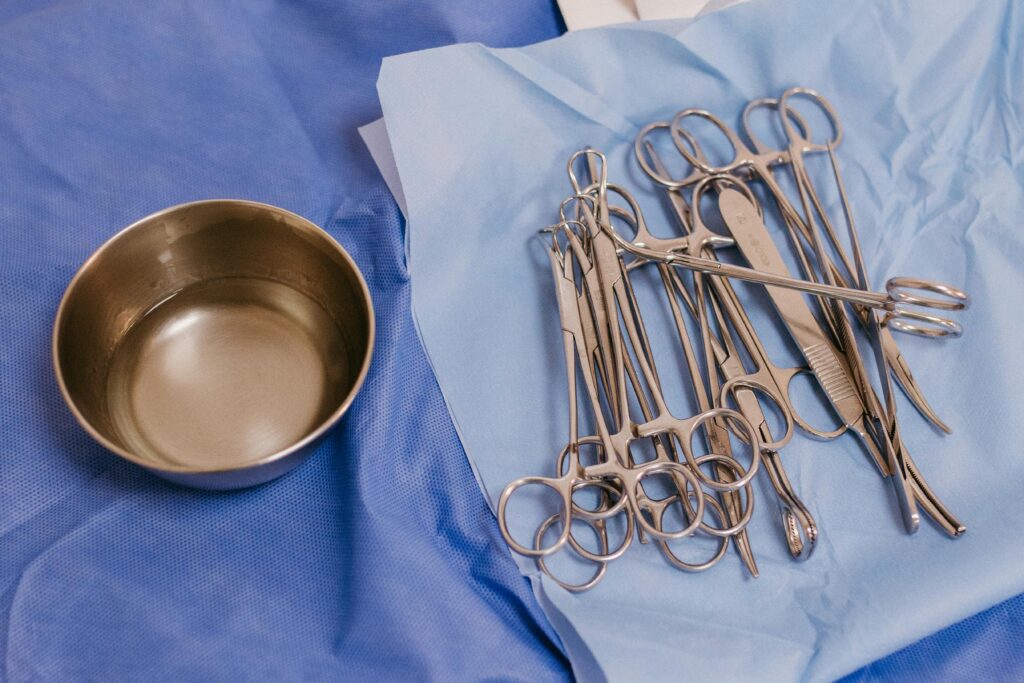 Sterile surgical instruments laid out on blue surgical drapes ready for medical procedures in a clinical setting.