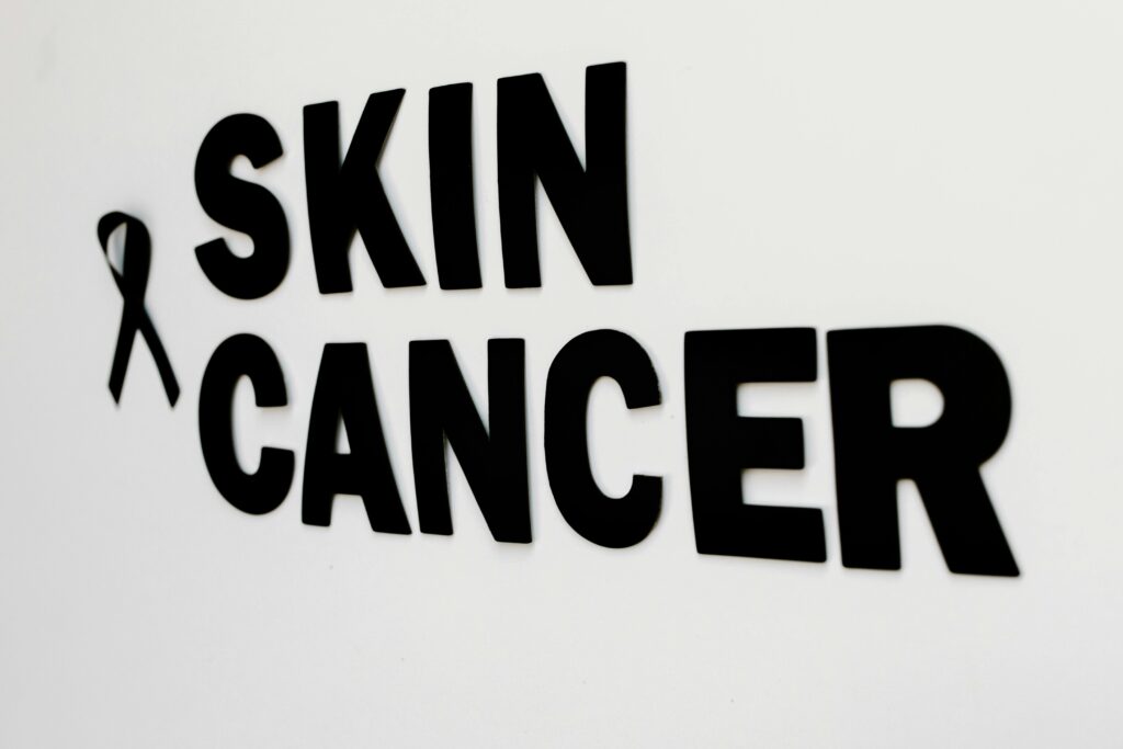 Close-up of black text and awareness ribbon highlighting skin cancer awareness.